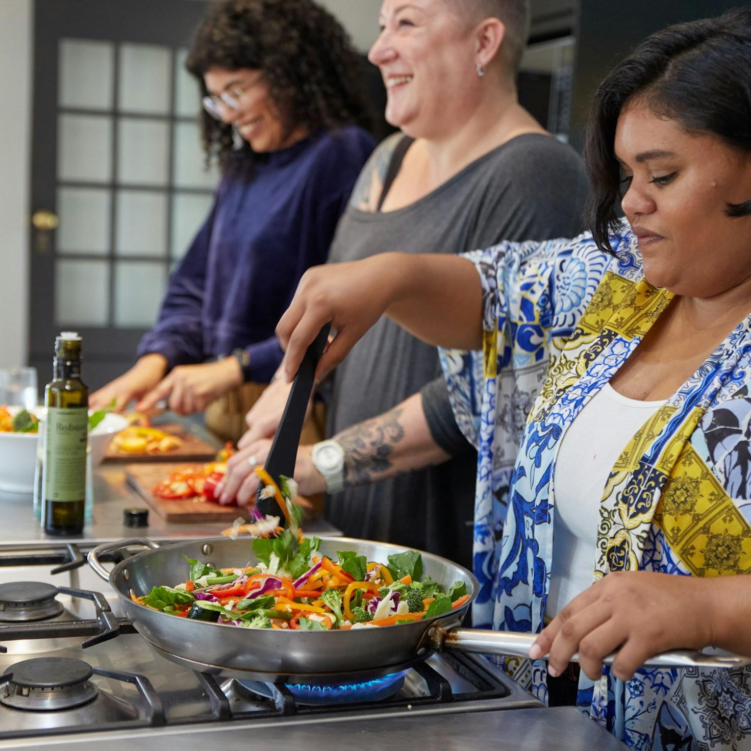Community members collaborating in a modern kitchen space, sharing recipes and cooking techniques